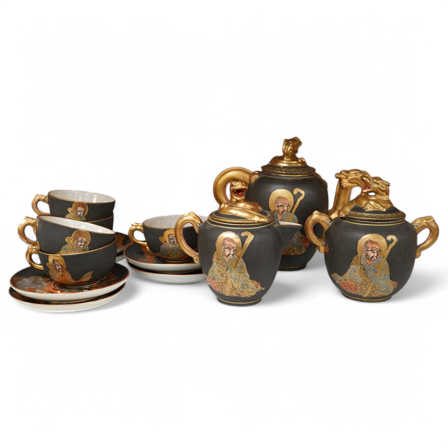 A Japanese Satsuma pottery enamel decorated tea set with Kwannon and rakan, teapot and cover 18cm high. Condition - one cup missing, one cup cracked